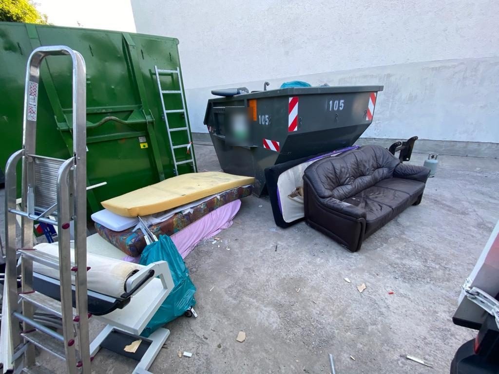 Sofa, Matratzen und Sperrmüll neben einem Container in Stuttgart